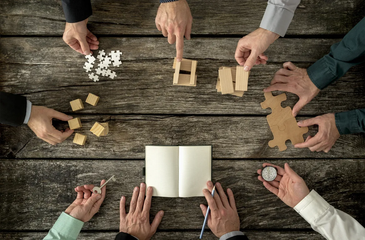 Manos uniendo piezas de puzzle y dando ideas